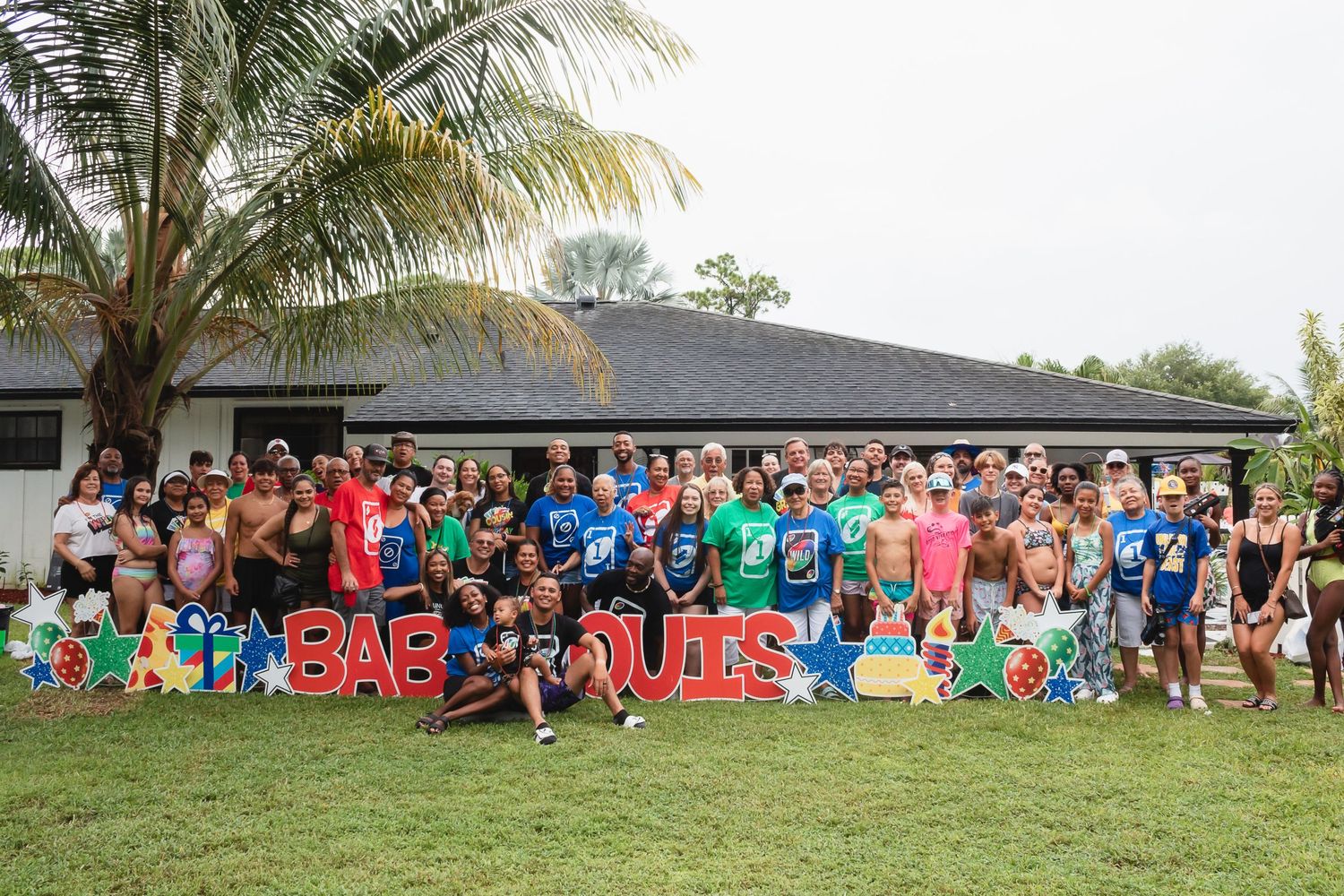 Large group gathered outdoors for a special event with UNO-themed decorations.