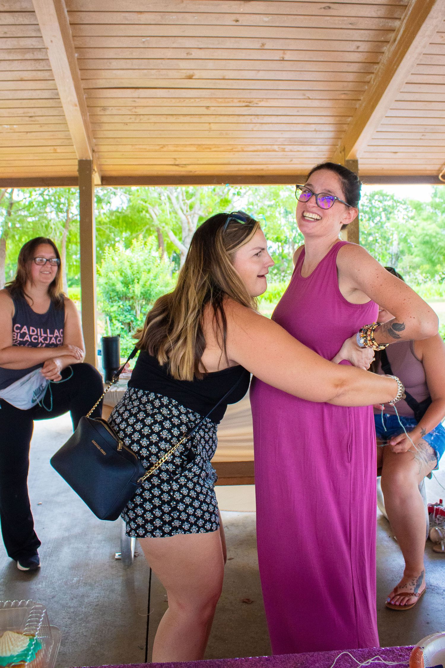 Joyful celebration moment captured at an outdoor party under wooden pavilion.