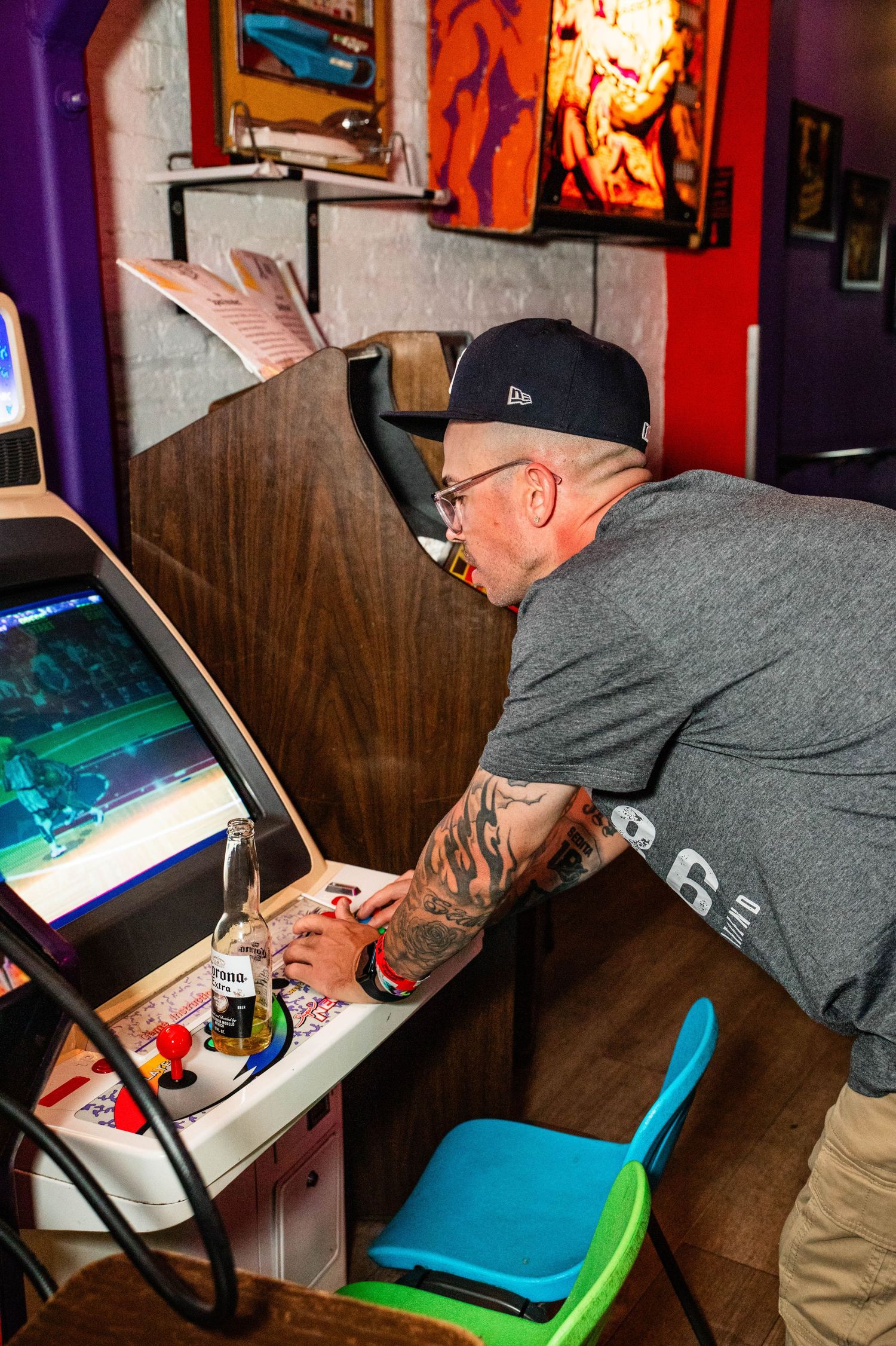 An older man playing a video game on a retro arcade machine.