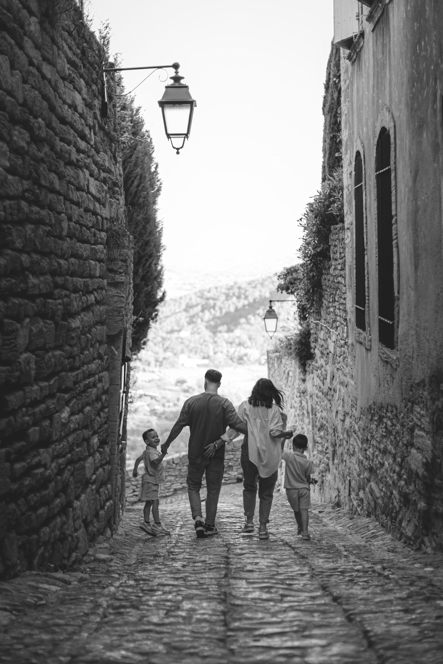 Une famille avec deux parents et deux enfants dans une rue du village de Gordes en Provence qui se tiennent par les mains