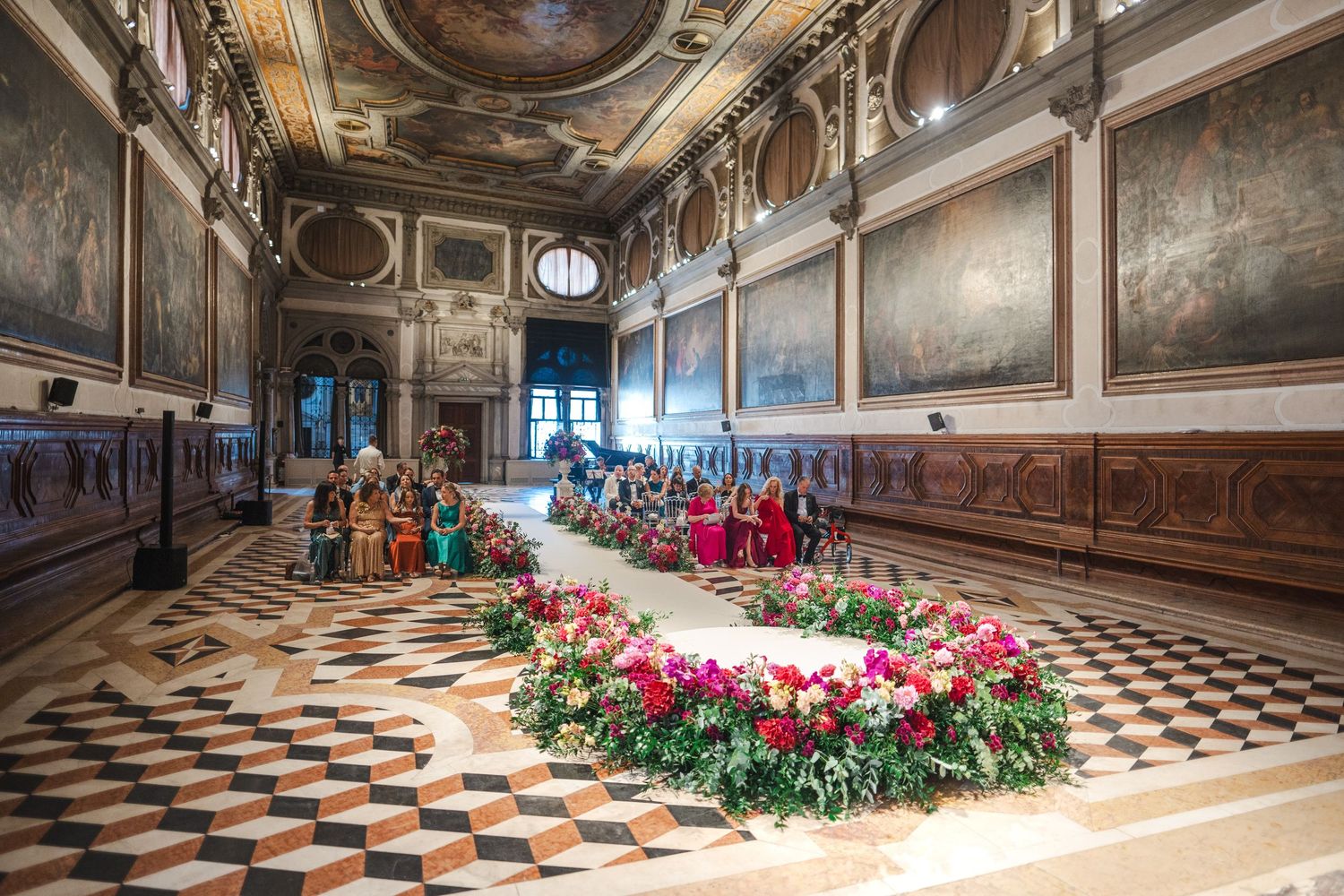 Opulent Venetian hall adorned with a grand circular floral arrangement on a marble mosaic floor.