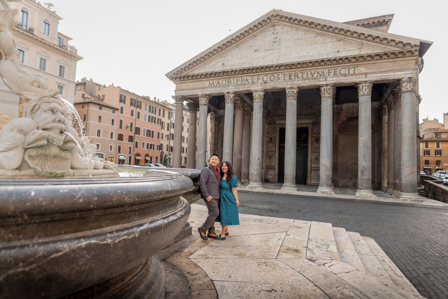 Couple posing by a fountain in Piazza della Rotonda with the ancient Roman Pantheon in the background, Rome, Italy.