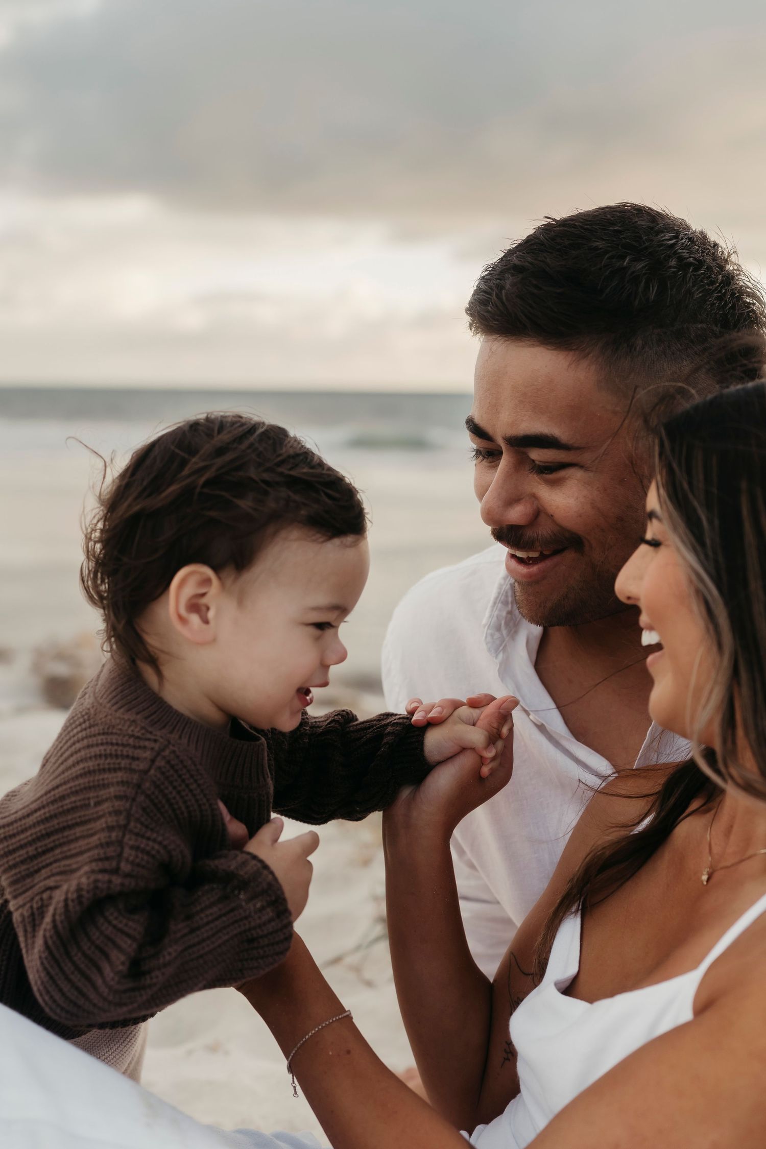 Happy family sharing an intimate moment together at the beach during sunset.