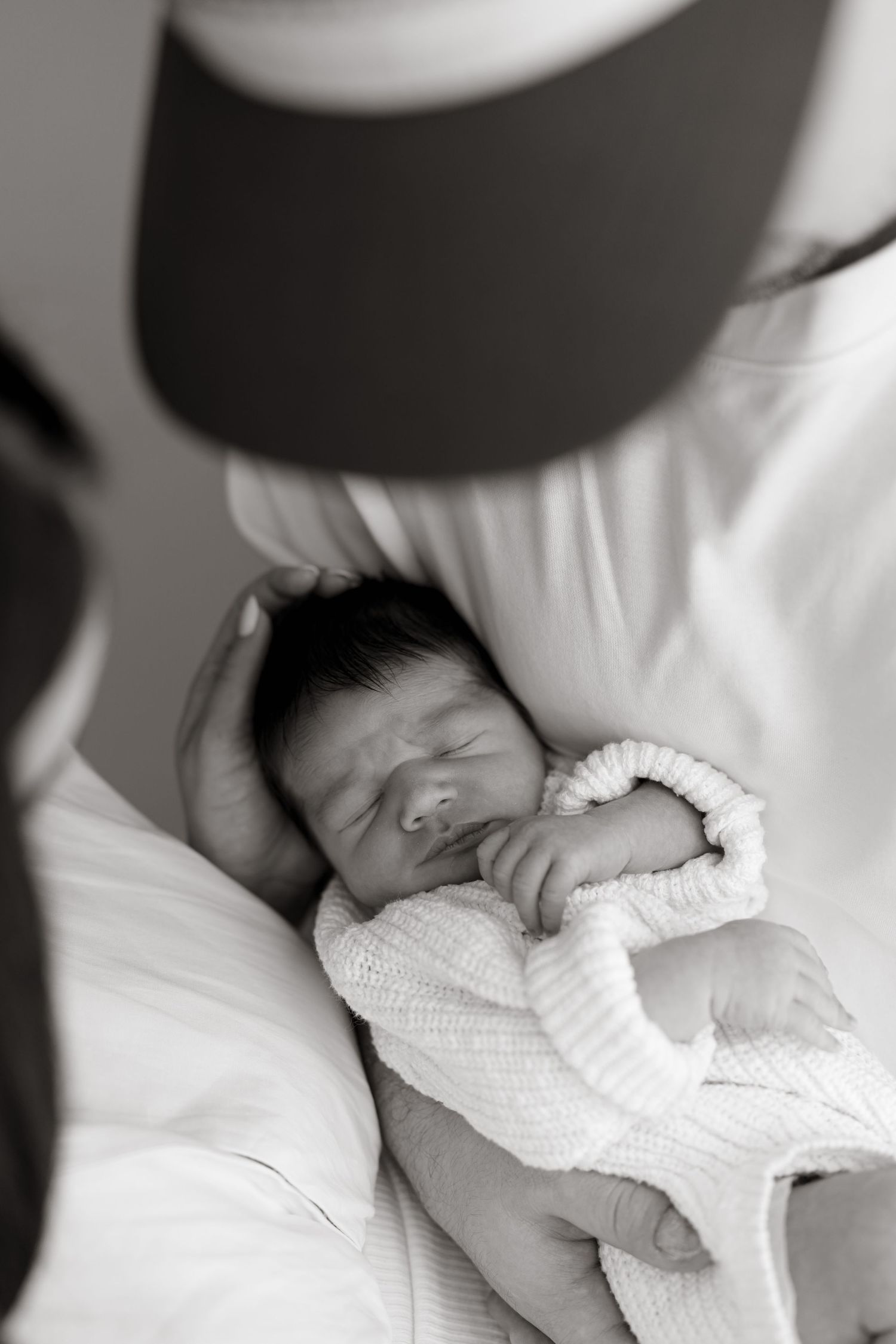 Black and white image of sleeping newborn baby wrapped in white knit clothing. Meg Rose Photos Perth WA.