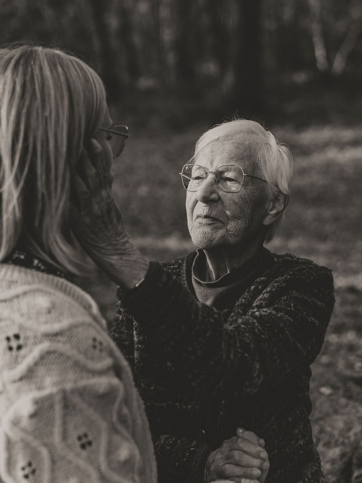 An emotional outdoor conversation between two individuals in black and white photography.