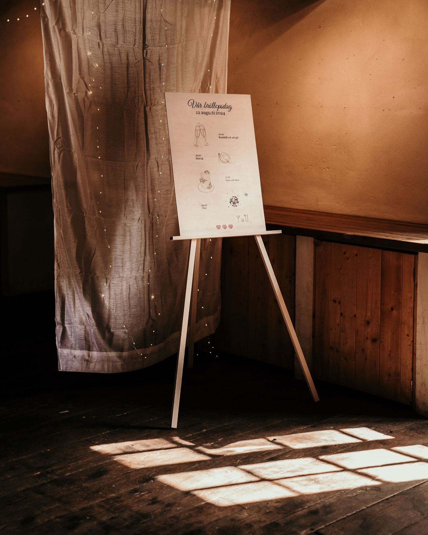 A wooden easel displays an instruction poster in a rustic room with dramatic window light casting geometric shadows.