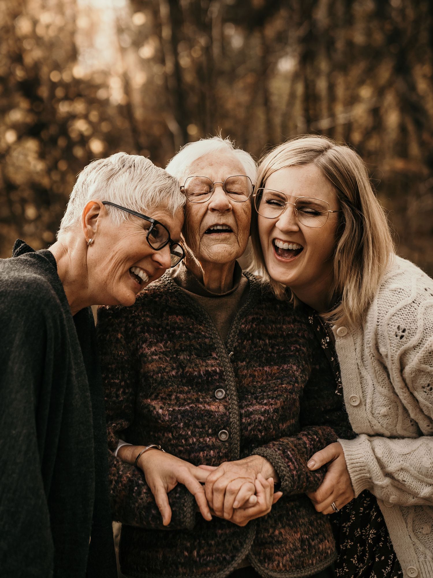 Three generations share an intimate moment of pure joy and laughter together on a warm autumn day.