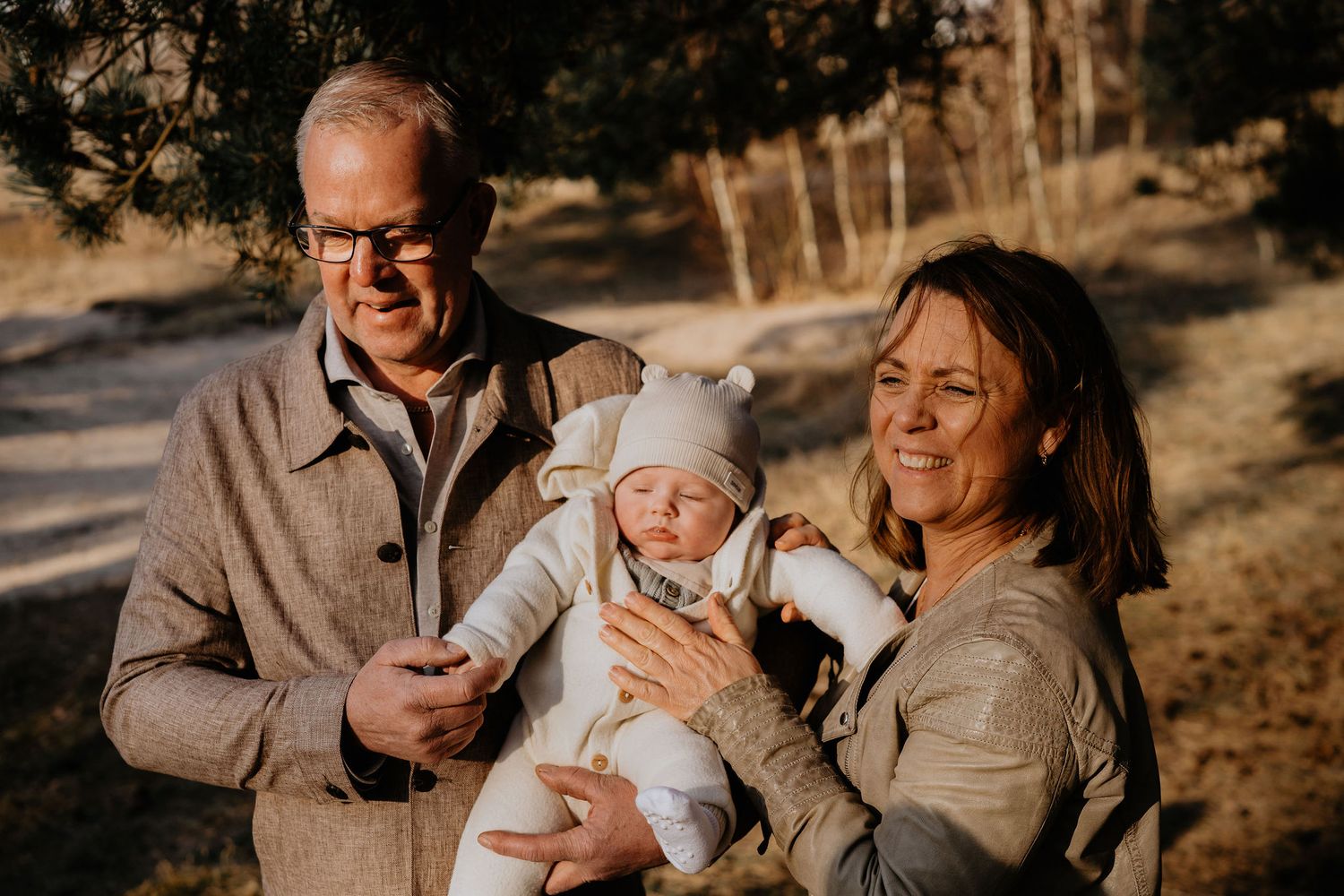 A family shares a joyful outdoor moment together during golden hour on a wooded path.