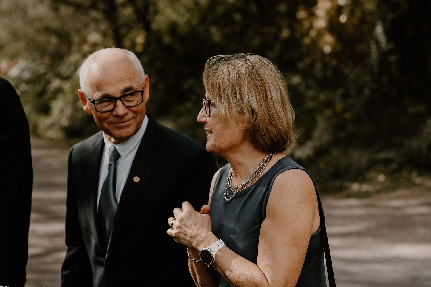 Two people share a heartfelt conversation outdoors during a formal event.