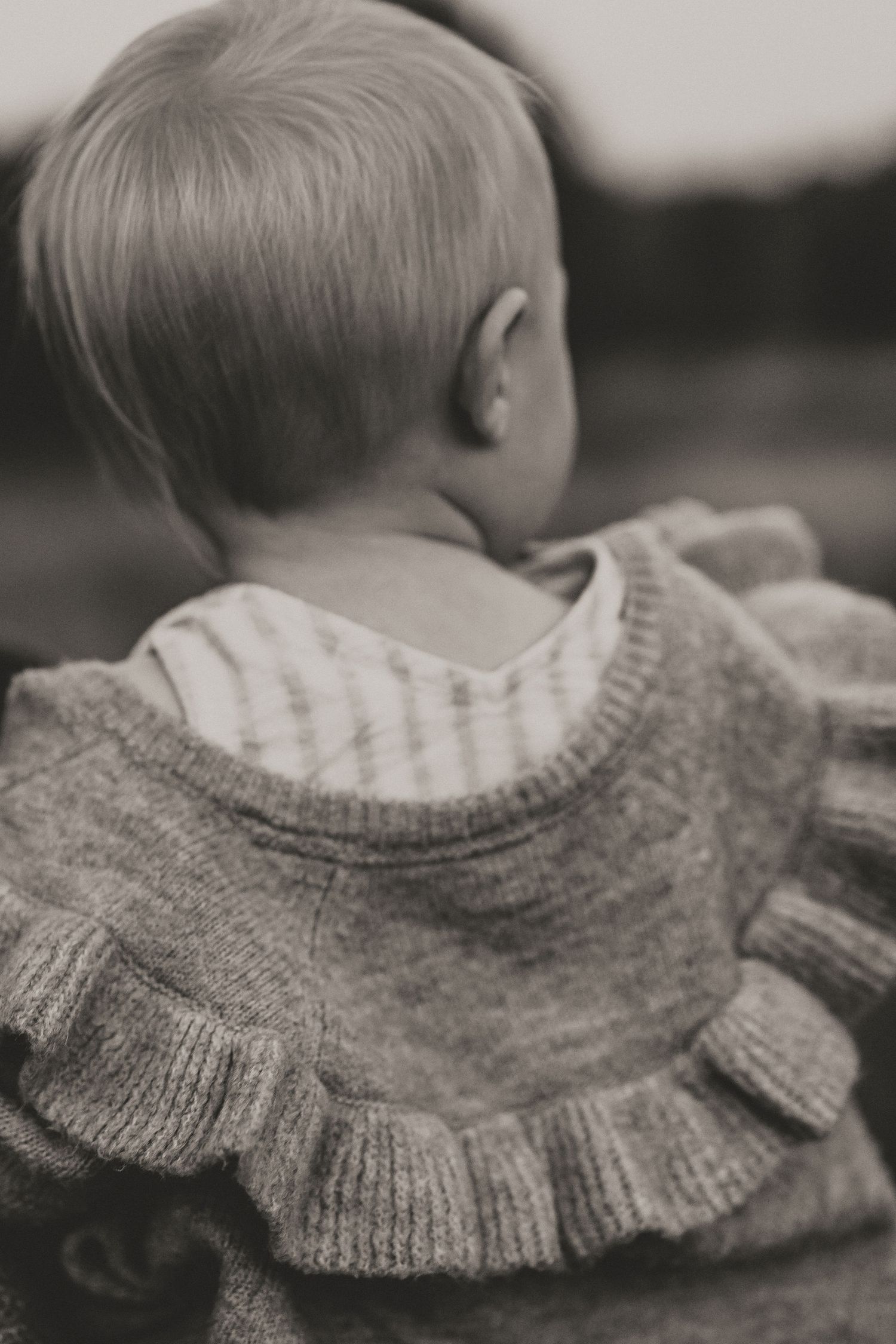 Close-up black and white detail of knit sweater with ruffled collar.