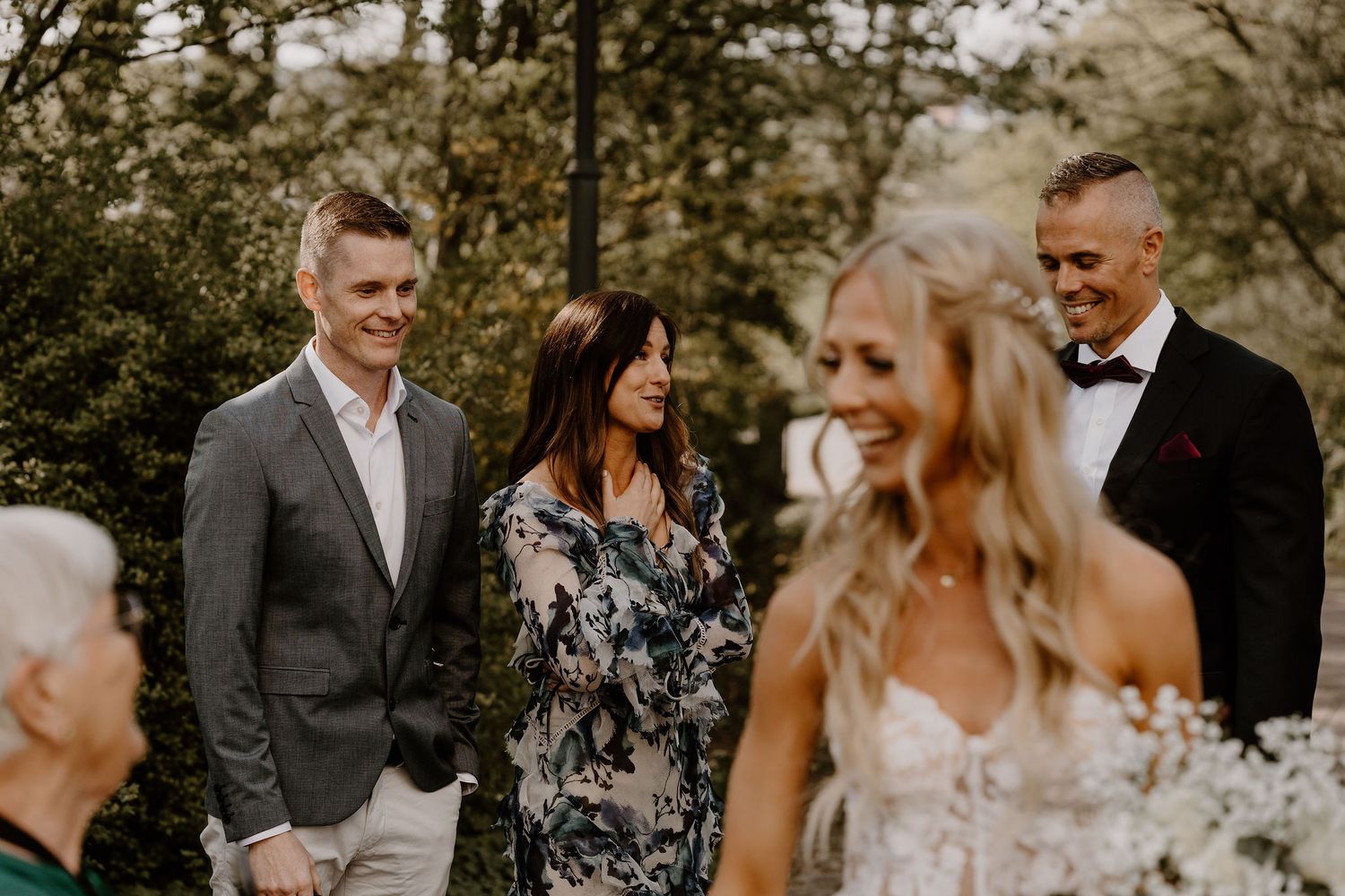 A small group of people gathered outdoors for a wedding ceremony on a warm autumn day.