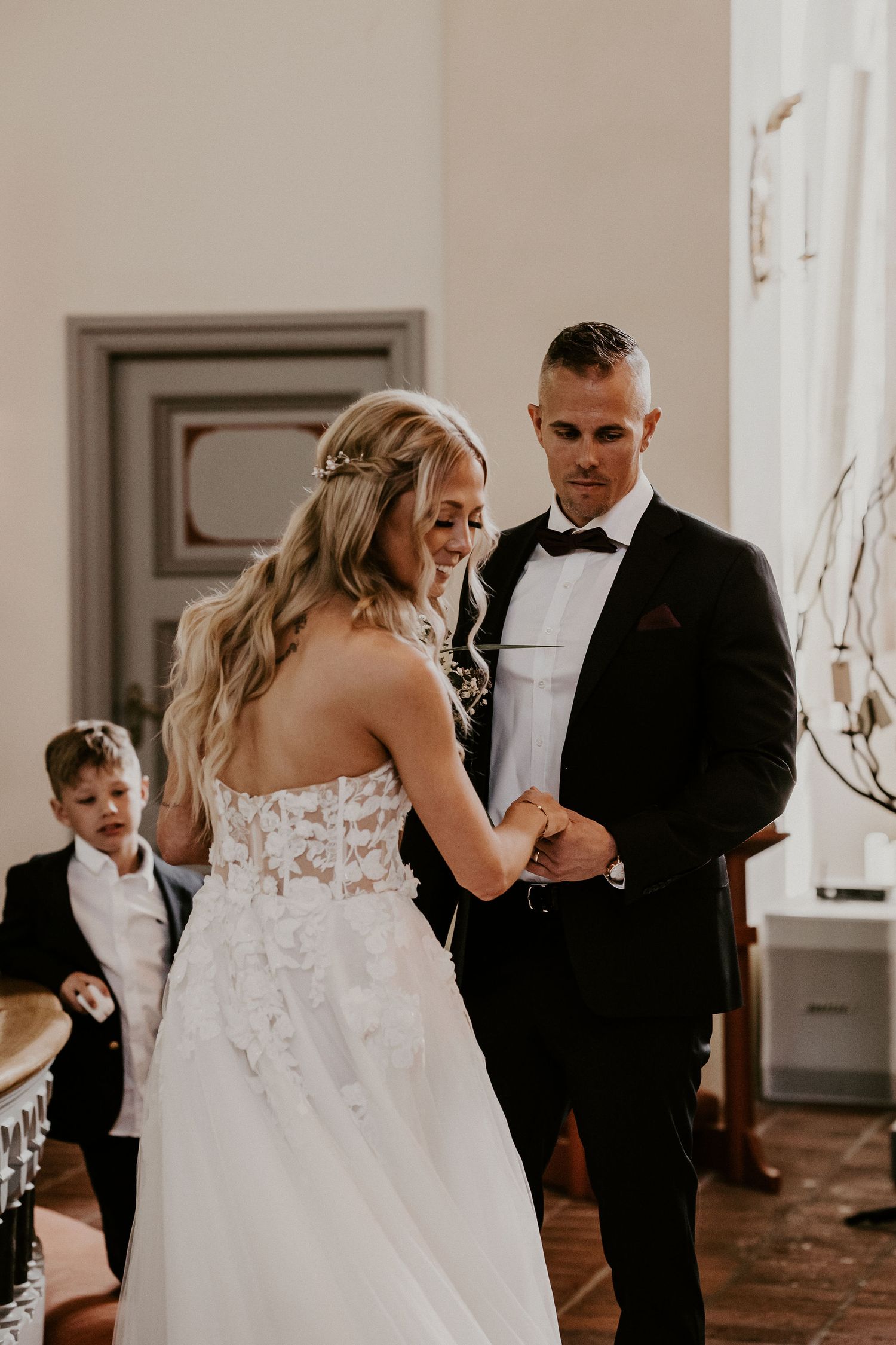 A couple shares their first dance at a wedding ceremony while wearing a beautiful white gown and classic black tuxedo.