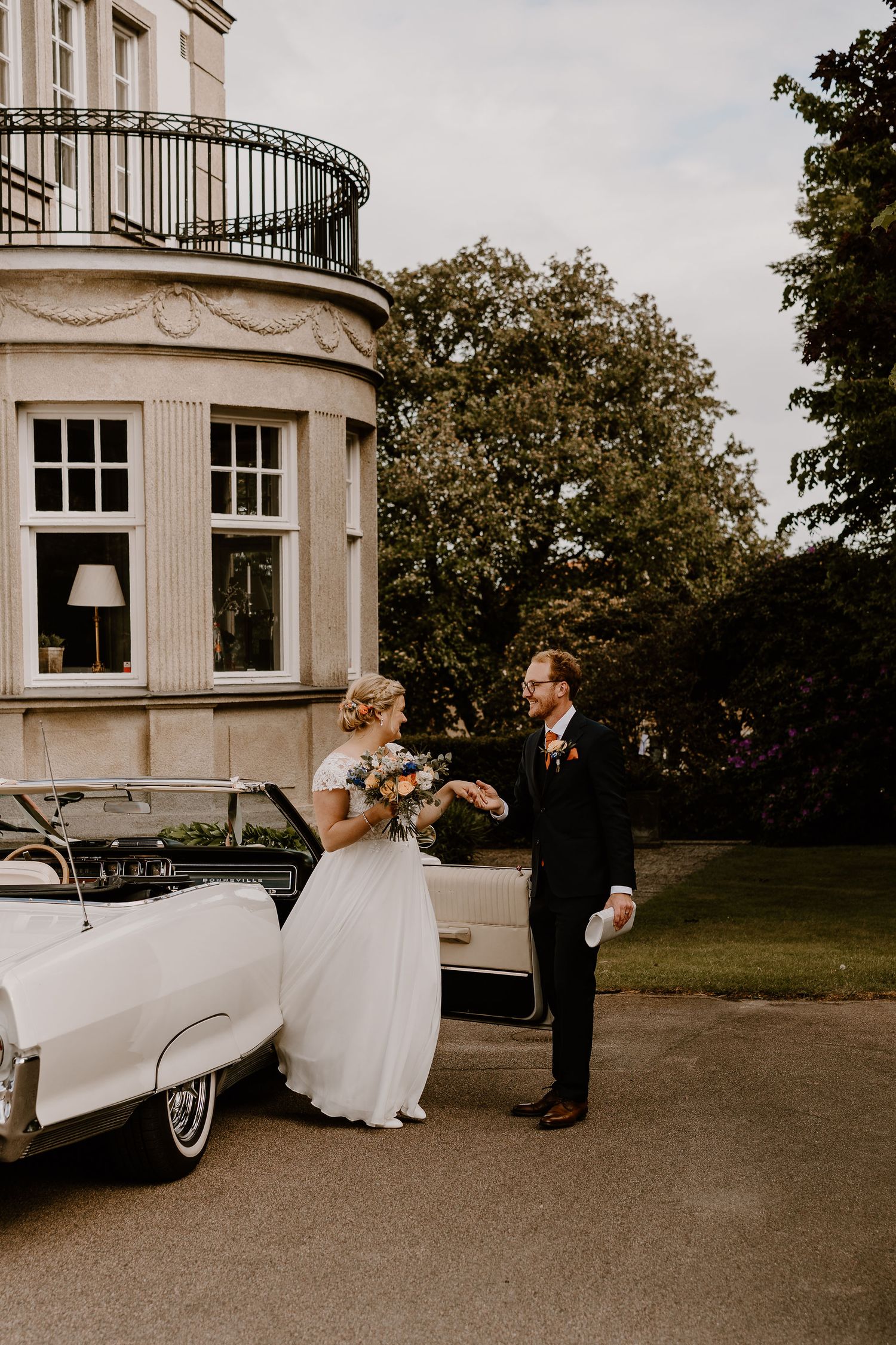 Ett brudpar kliver ut ur en Cadillac utanför ett slott i Halmstad.