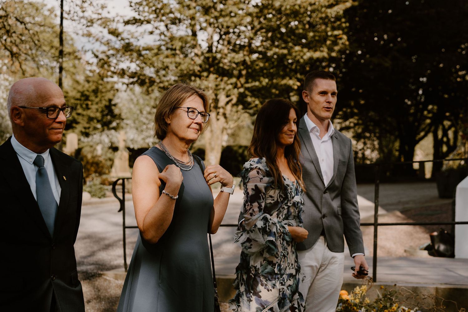 Group of attendees sharing joyful reactions during an outdoor gathering with natural lighting.