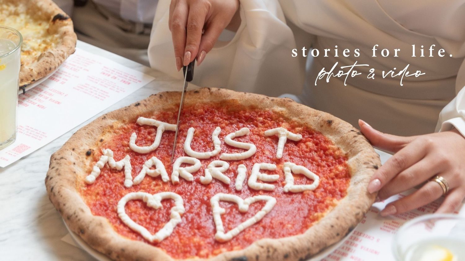 A just married pizza with heart decorations being cut, next to a stories for life photo and video logo.