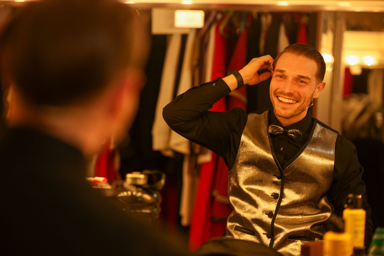 A series of candid photos showing someone smiling and laughing while seated in a dimly lit restaurant setting.