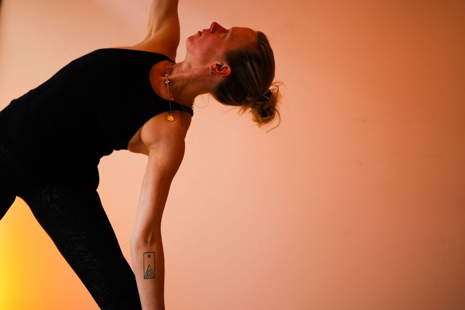 A series of five silhouetted dance poses against an orange and yellow gradient background.