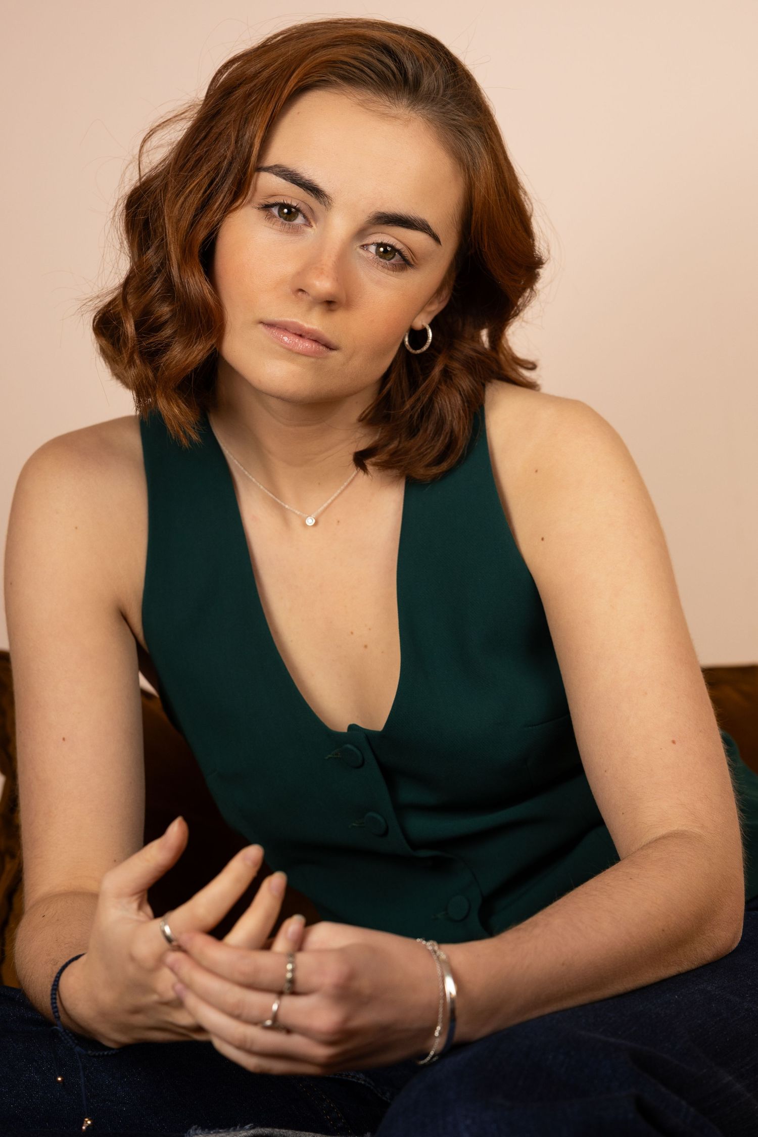A sequence of portrait shots showing someone in a dark green sleeveless top against a light background.