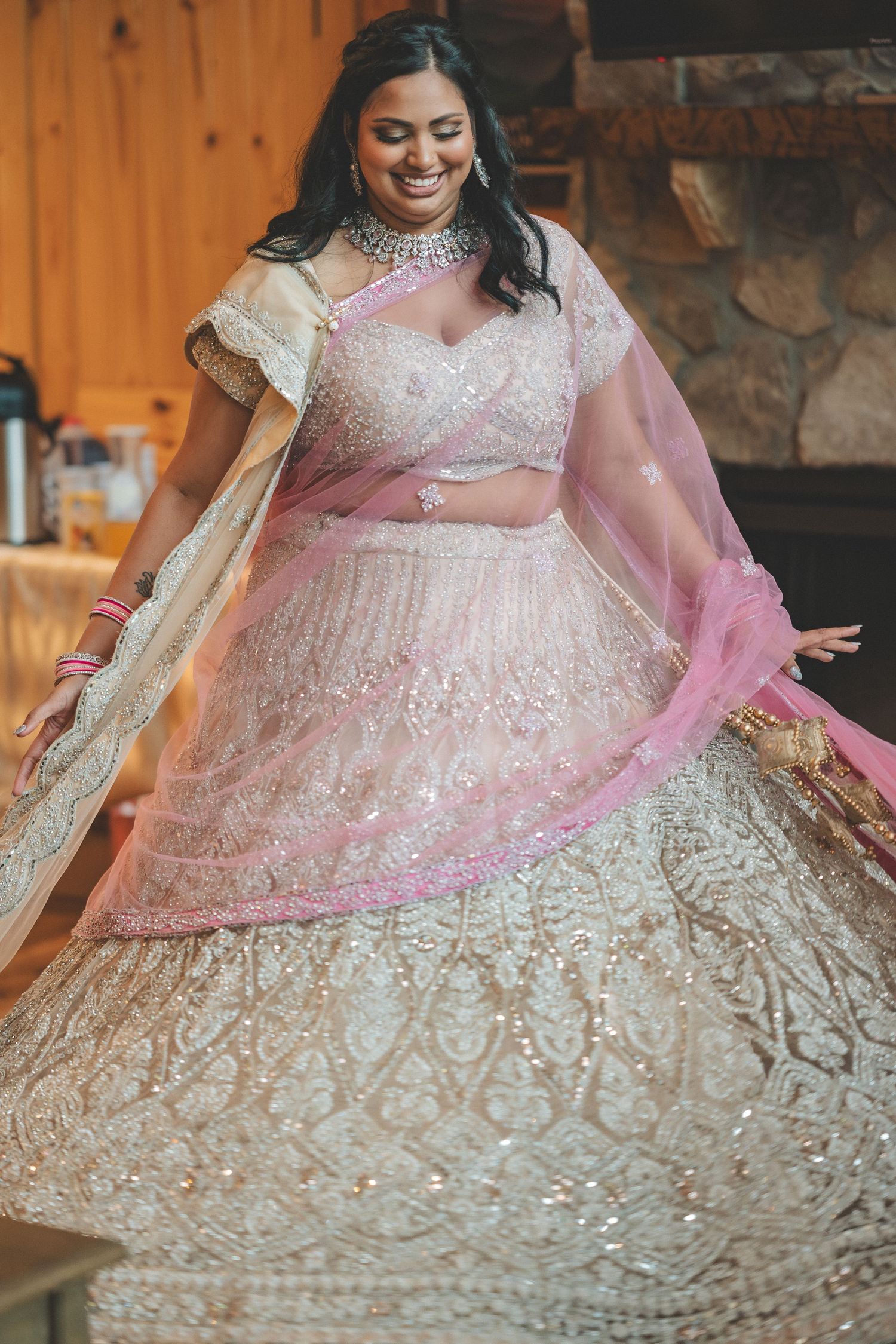 Close-up details of an ornate white and pink Indian wedding lehenga with intricate embroidery and sequins.