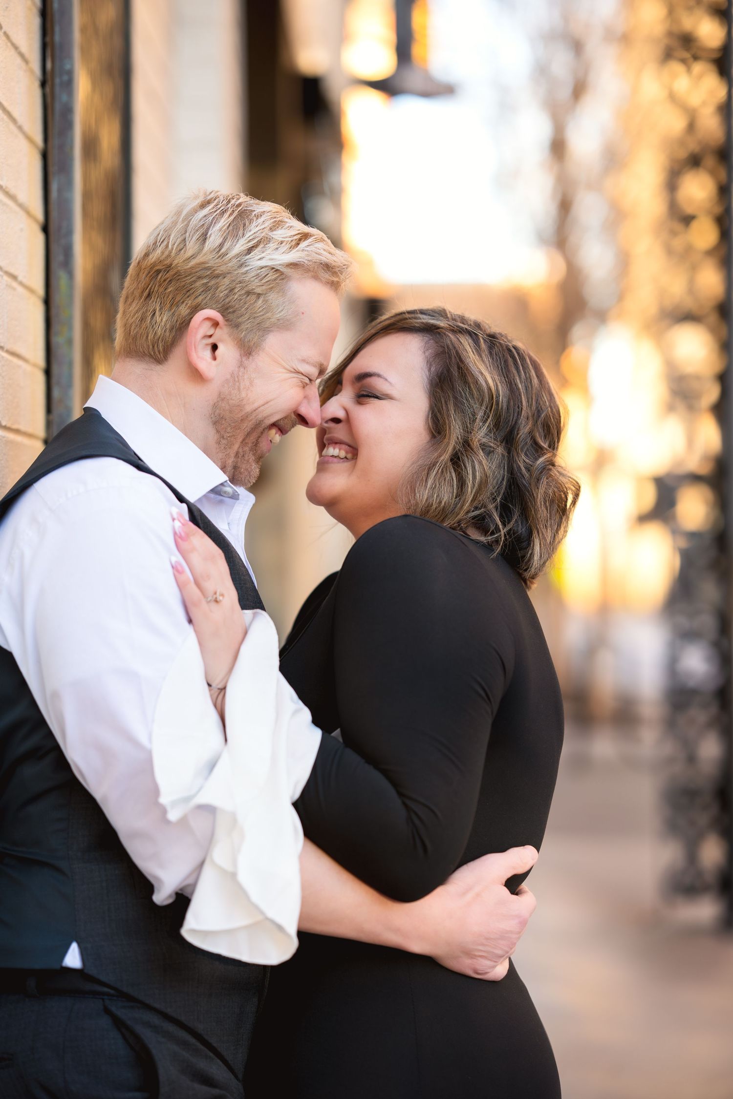 A couple shares tender embraces and laughter during a romantic outdoor photo session at golden hour.