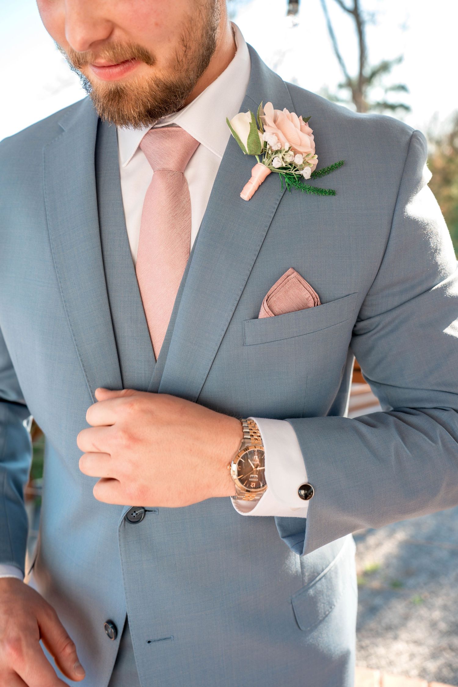 Close-up detail shots show ties, boutonnieres, and suits in soft pink and gray tones for a coordinated wedding party look.