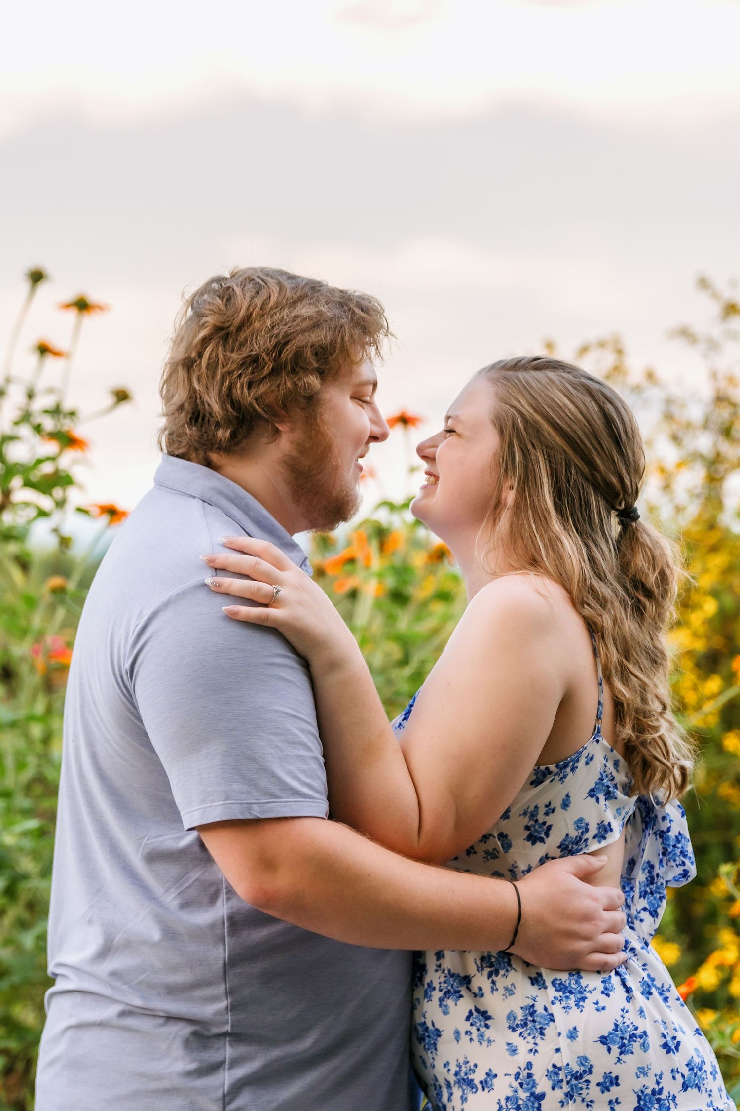 A couple shares tender moments surrounded by blooming sunflowers at sunset in a romantic field portrait session.
