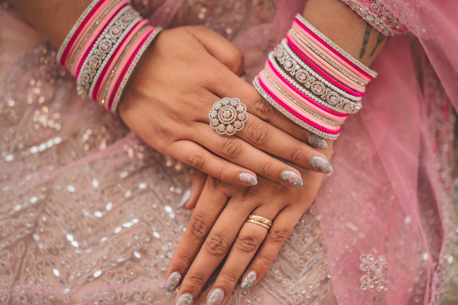 Close-up sequence of hands with engagement ring and pink and silver bangles showing sparkle and detail of jewelry.