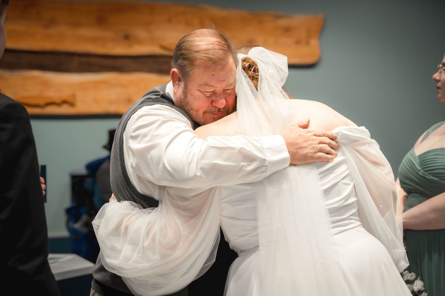 Emotional moment captured at a wedding as two people share a tender embrace.