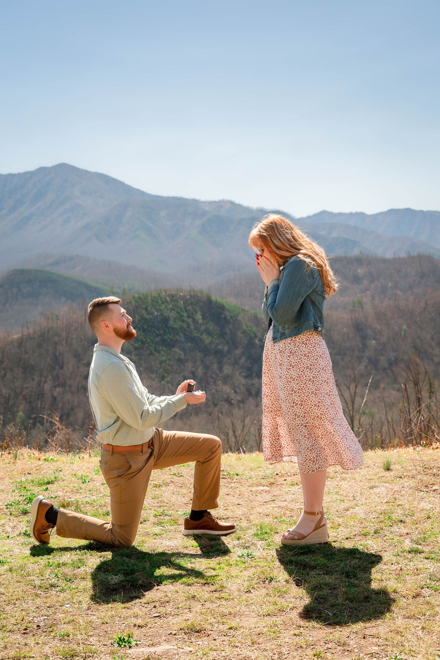 A scenic mountaintop proposal moment as someone kneels on one knee at sunset in the Smoky Mountains.