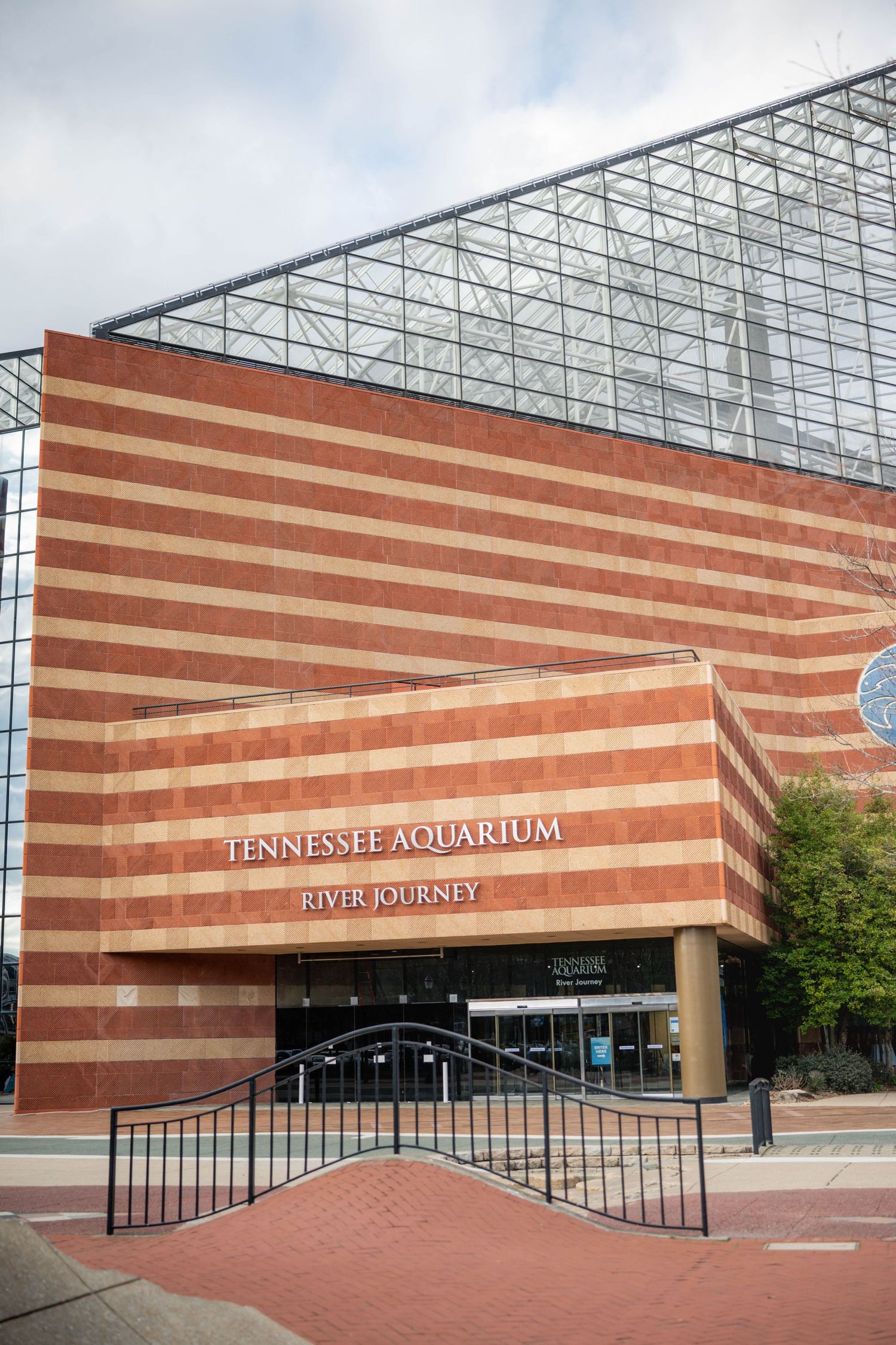 Front entrance of Tennessee Aquarium building with distinctive striped architecture and glass roof.