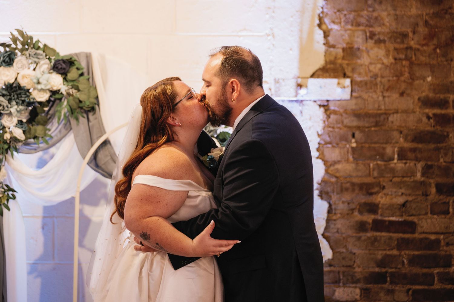 A romantic wedding collage showing couples sharing intimate first kisses at their ceremonies against rustic brick backdrops.