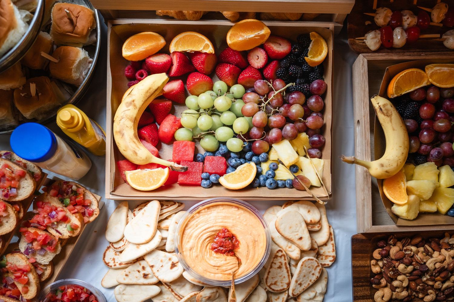 Colorful market display of fresh fruits, vegetables, and artisanal foods arranged in wooden crates and shelves.