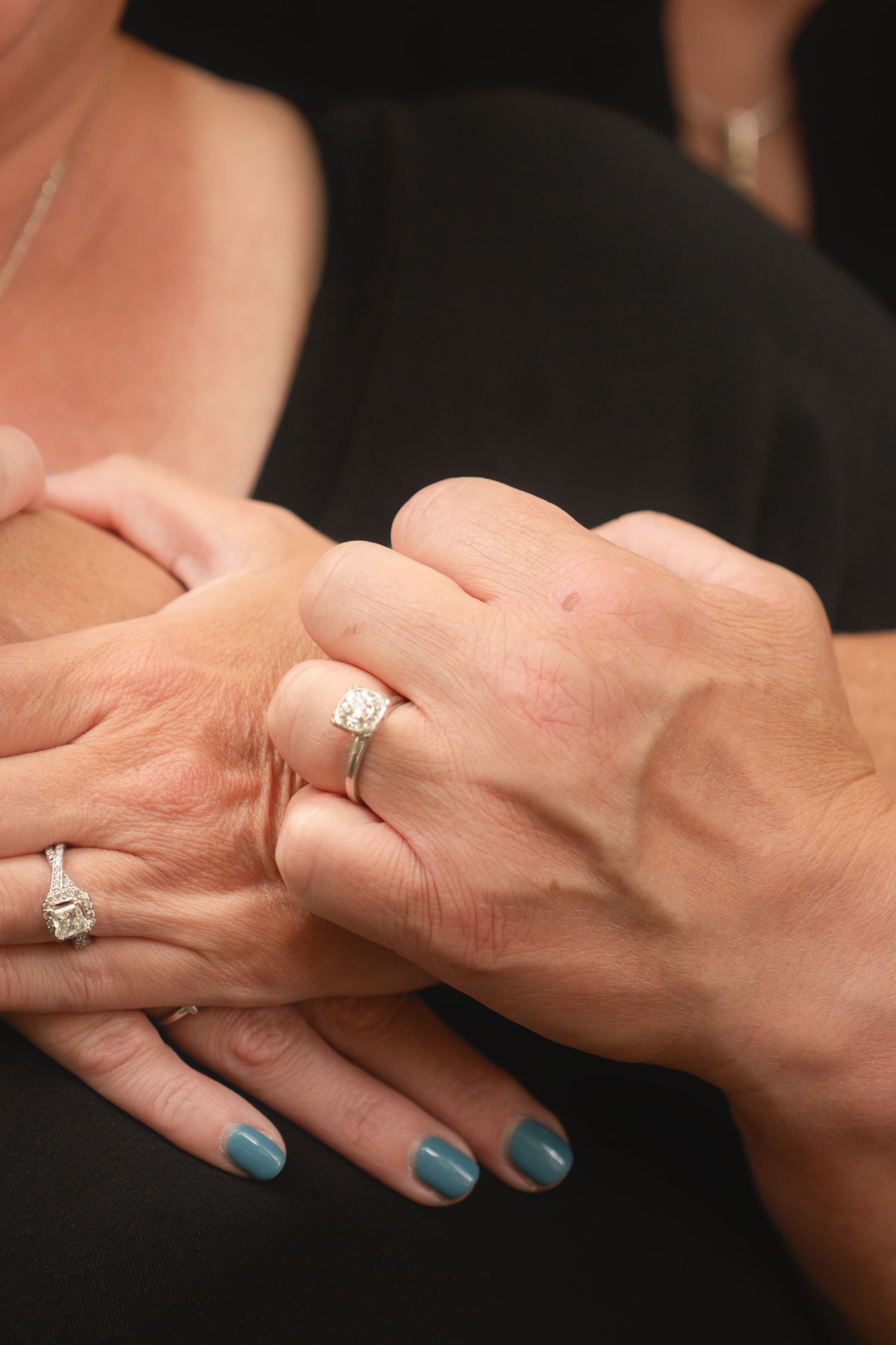 Close-up sequence of hands exchanging engagement rings with teal nail polish visible in romantic proposal moment.