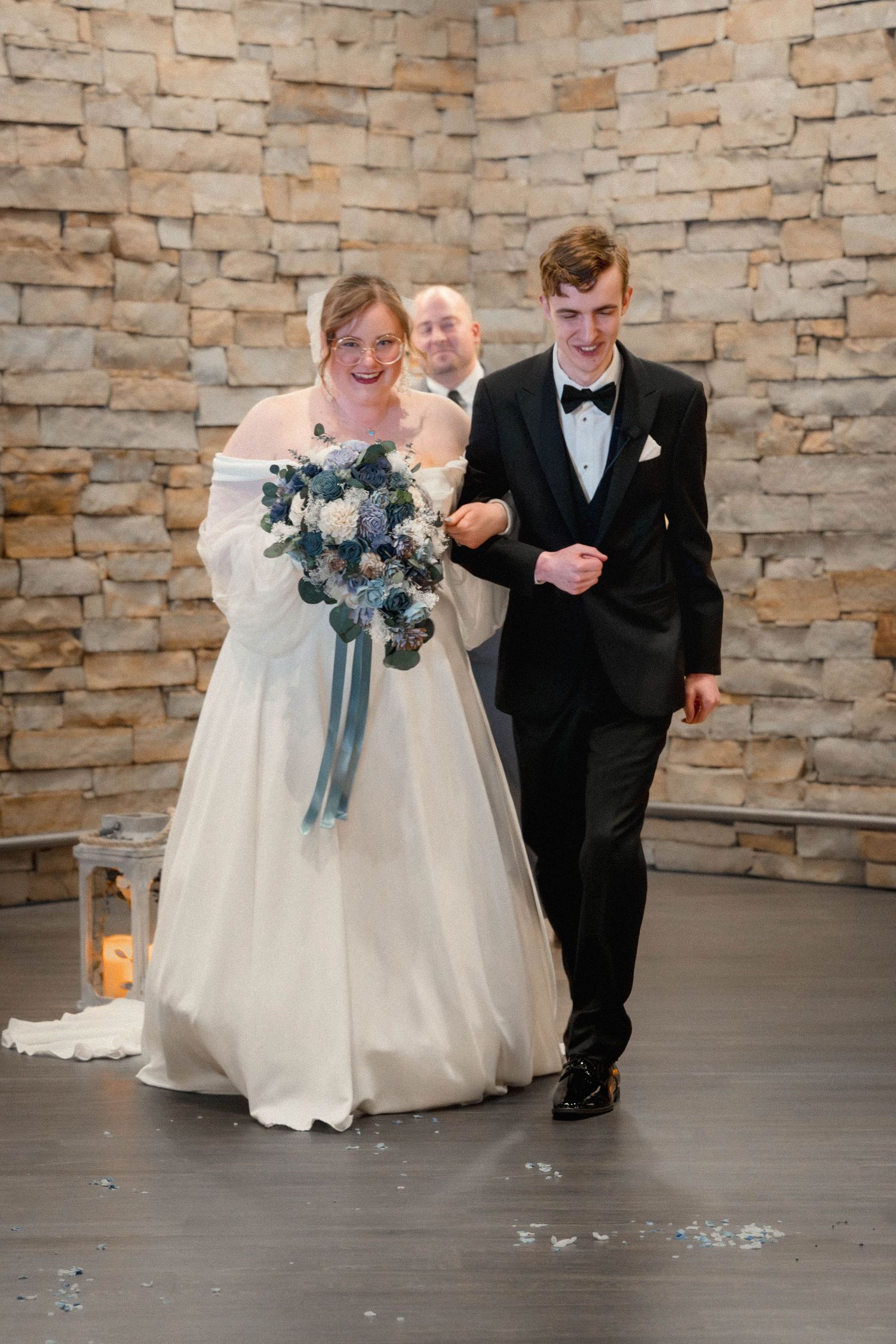A sequence of candid wedding photos showing a couple on a stone wall background in matching formal attire.