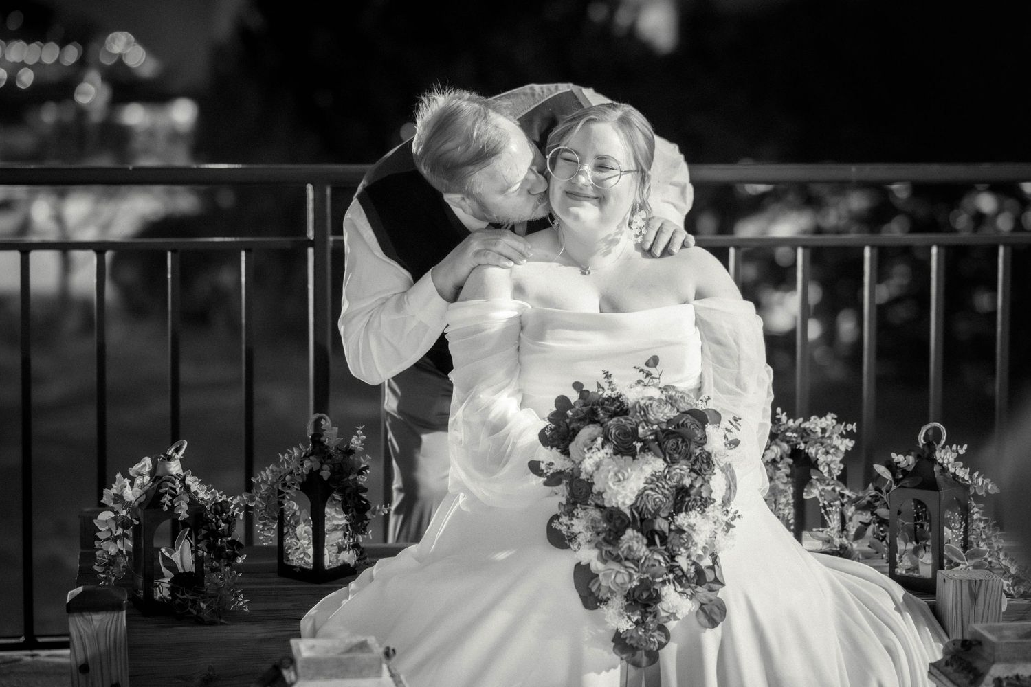 Black and white photo of couple sharing an intimate moment on balcony at their wedding.