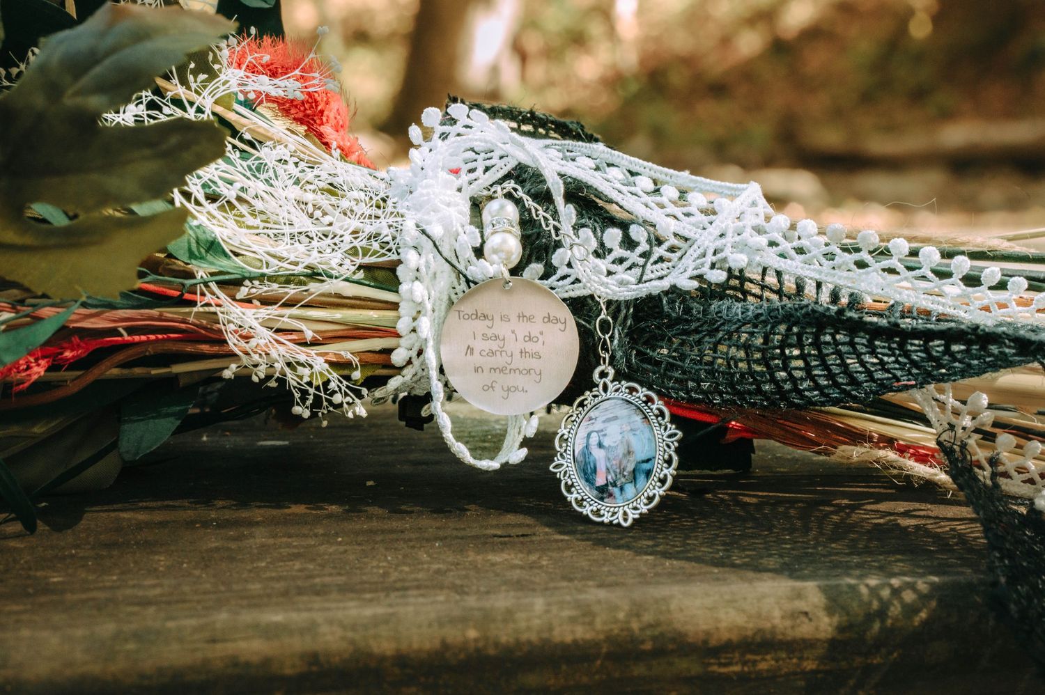 Wedding rings and delicate lace details arranged on rustic wooden surface with soft natural lighting.