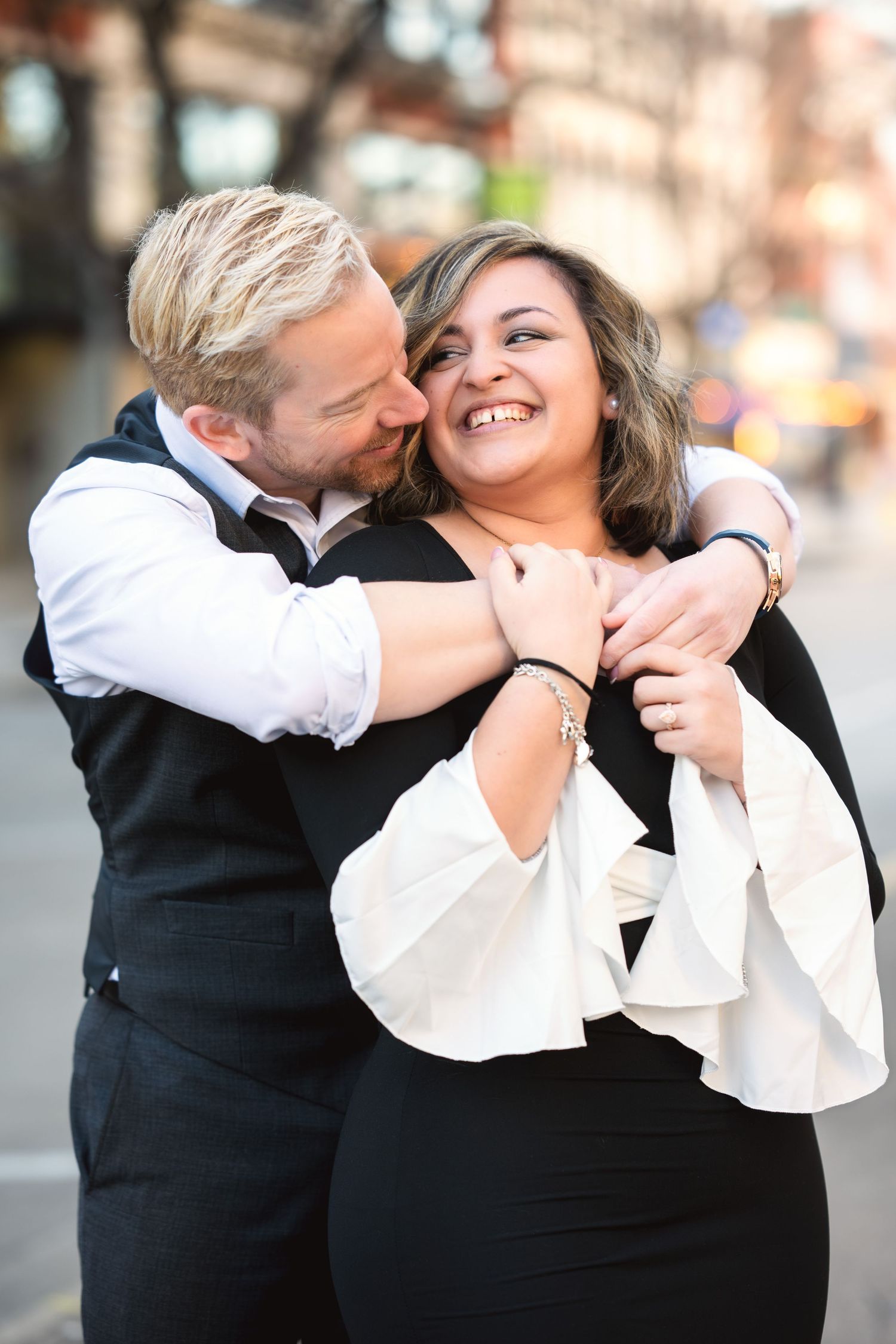 A romantic couple in black and white attire share intimate moments in a sequence of candid outdoor photos.