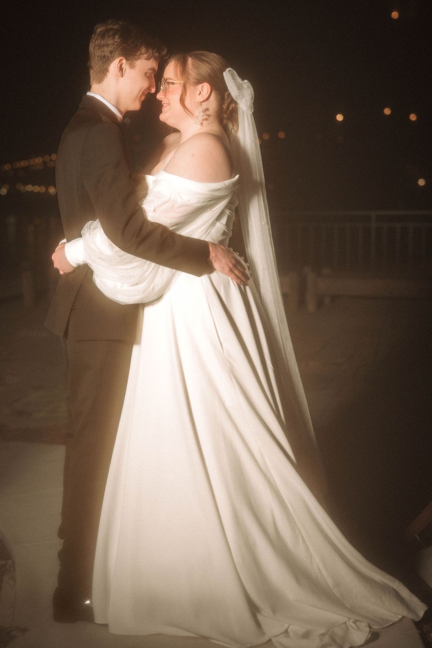 A romantic first dance at a wedding reception shows a couple in formal attire with a flowing white dress and veil.