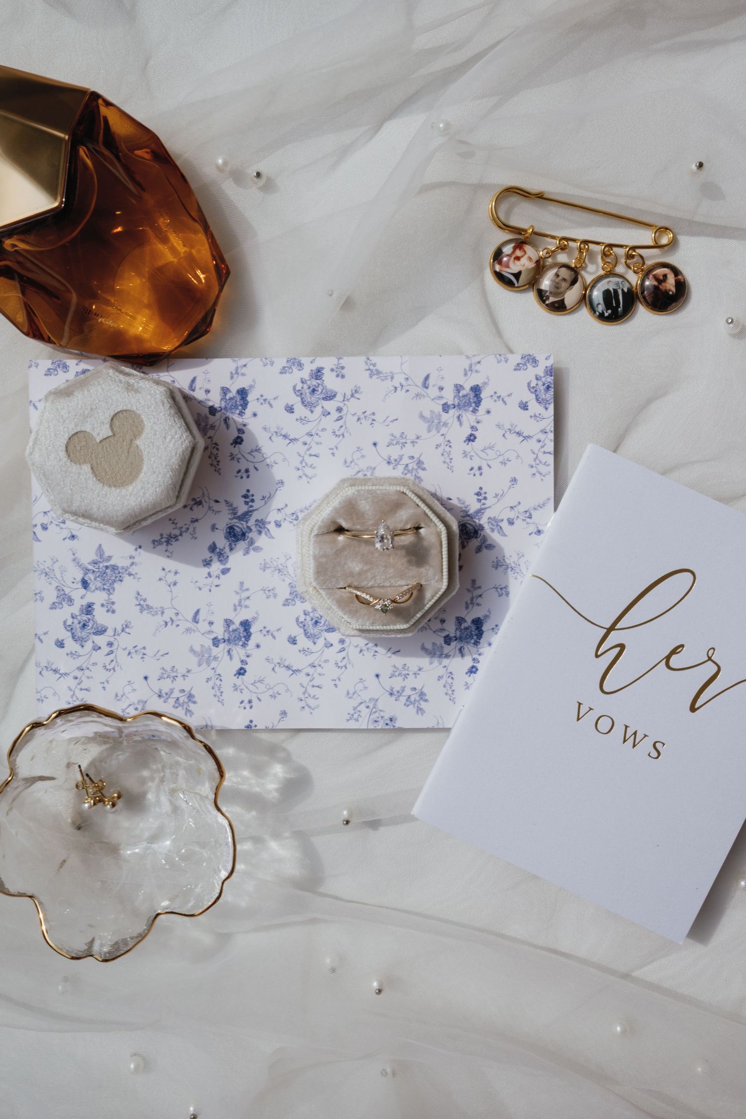 Elegant wedding invitation cards and accessories with watercolor details and gold accents on white marble background.