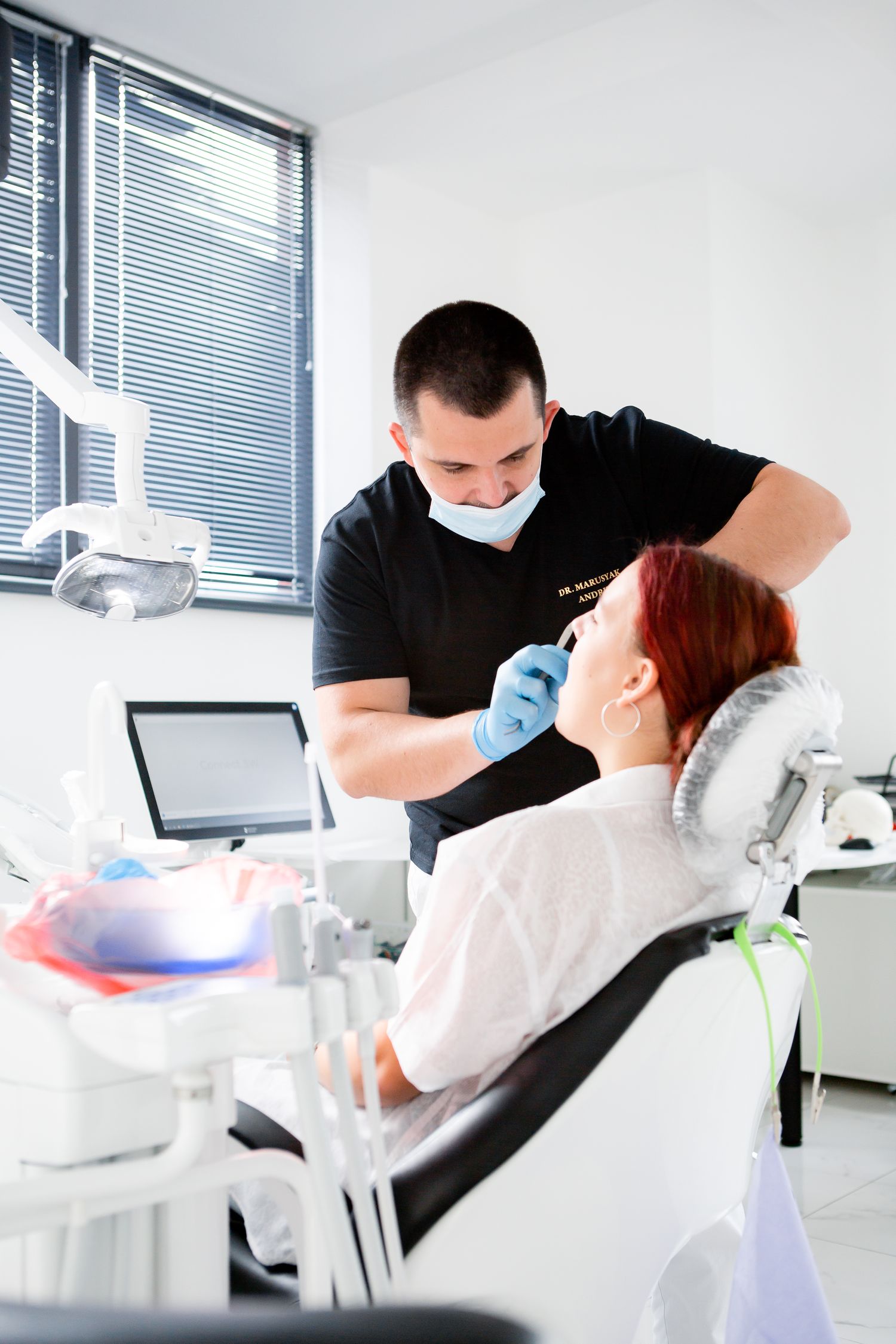 Dental examination taking place in a modern clinic with blue medical gloves.