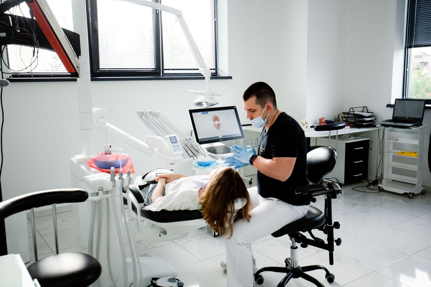 Dentist treating a patient in a modern dental office with specialized equipment.