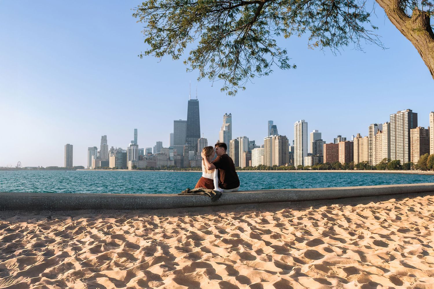 Chicago skyline view from North Avenue Beach with Lake Michigan and sandy shoreline in the foreground.