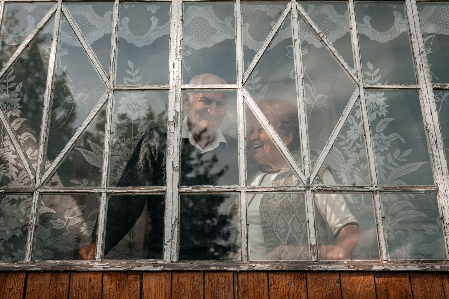View through an old window with geometric metal frame patterns.