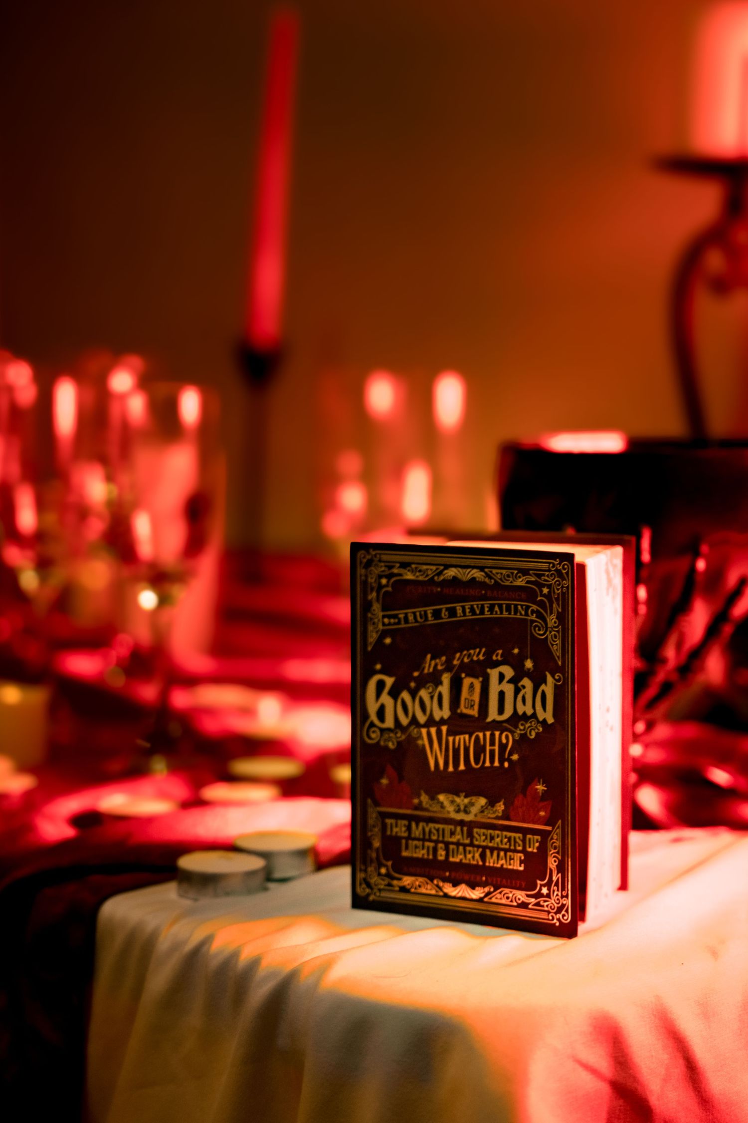 Book titled 'Good vs Bad Witches' displayed on table with red ambient lighting.