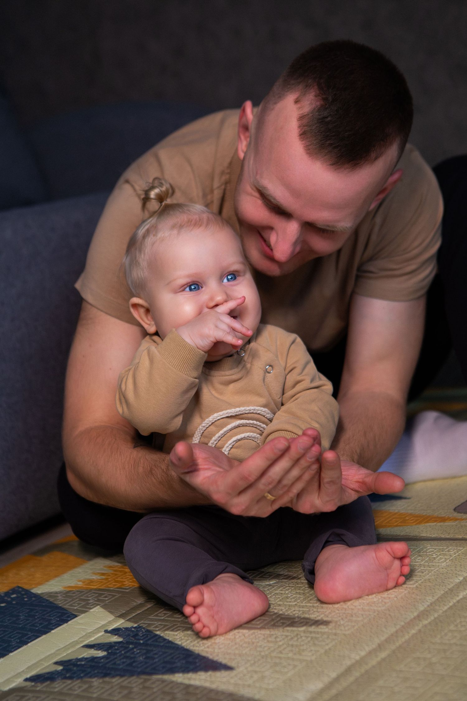 A series of progressive photos showing a parent and baby reading a book together while lying on the floor.