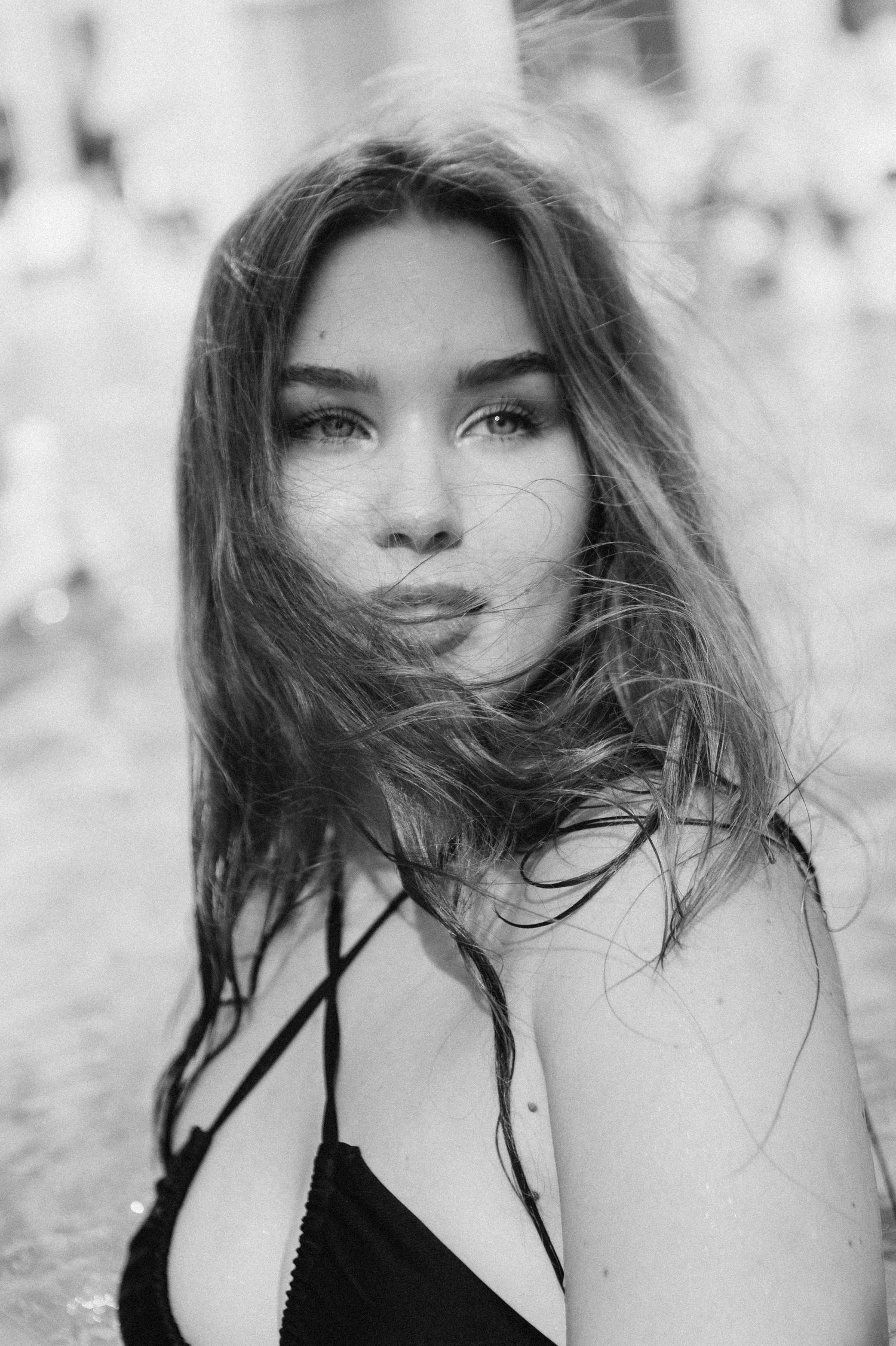 A series of black and white artistic portrait photos showing hair blowing in the wind with dramatic lighting effects.