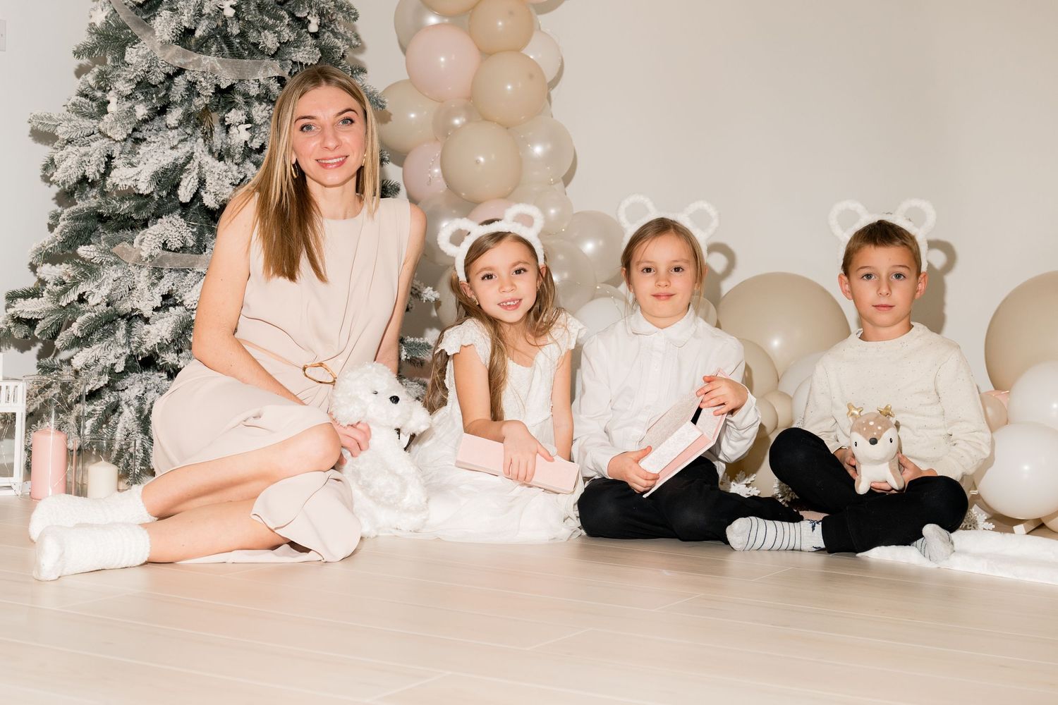Holiday photo scene with frosted Christmas tree and balloon decorations.