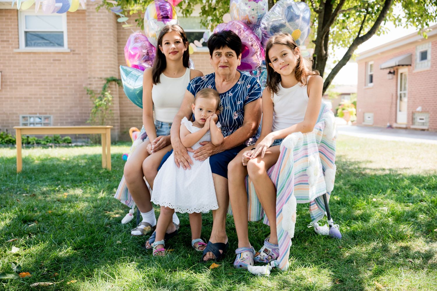 A cheerful outdoor birthday celebration with colorful balloons and decorations on a sunny summer day.