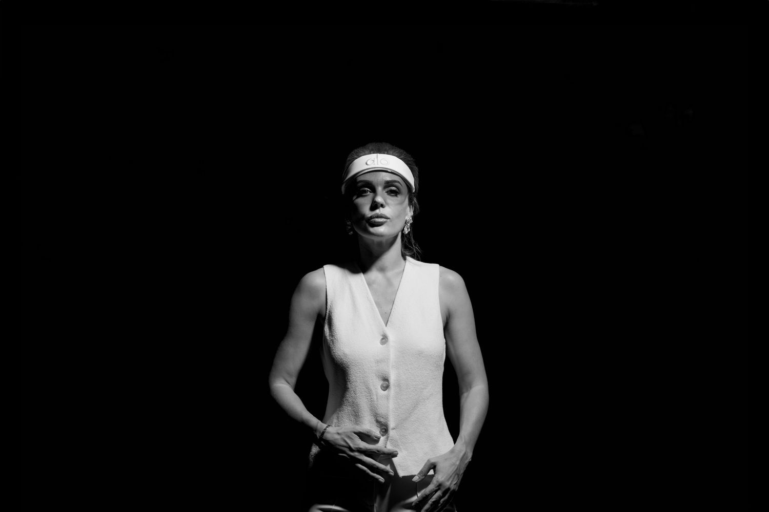 Sporty figure in white athletic wear against dark background.