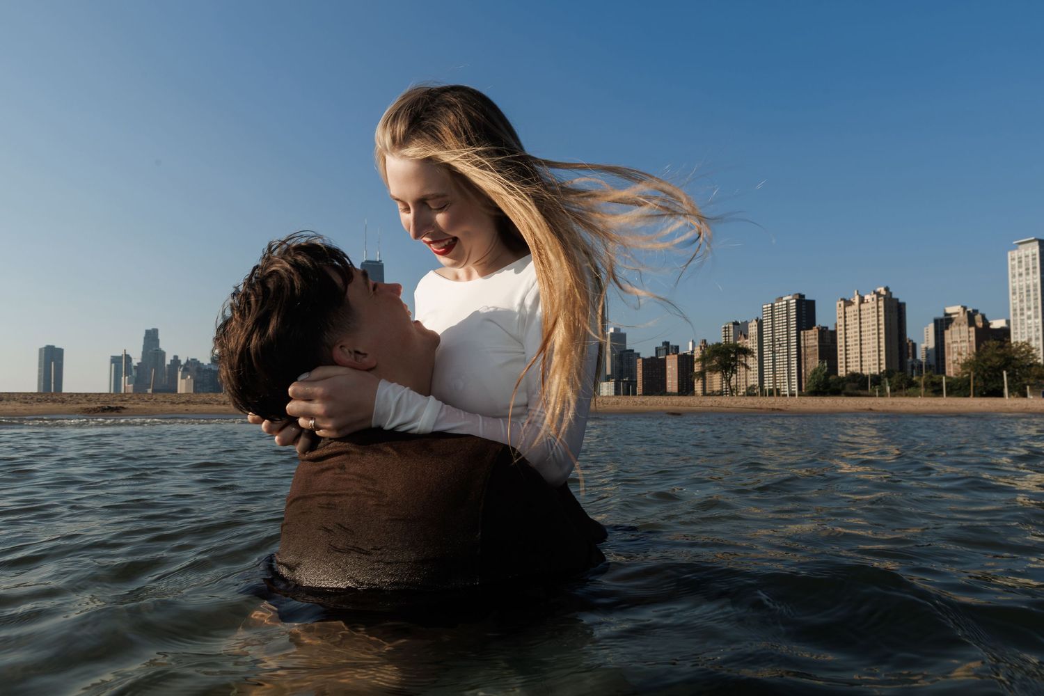 A series of ocean swimming photos showing someone diving and splashing in blue water with a cityscape in the background.
